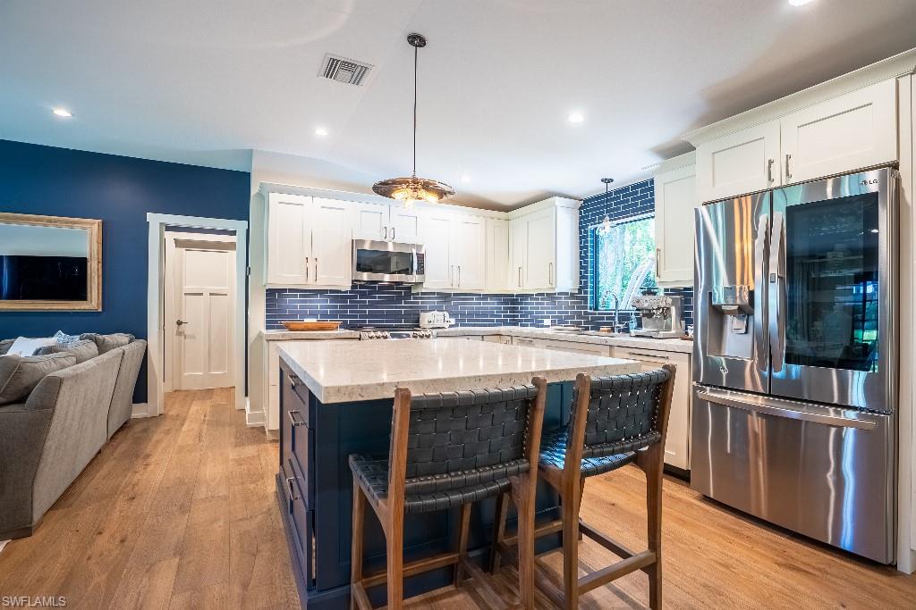 Kitchen featuring a central island with a light-toned countertop and contrasting dark base