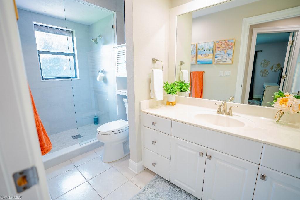 Bathroom featuring a spacious vanity with white cabinetry, a single basin sink, and a light-toned countertop