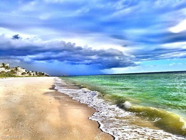 Beachfront property with sandy shore and foamy waves