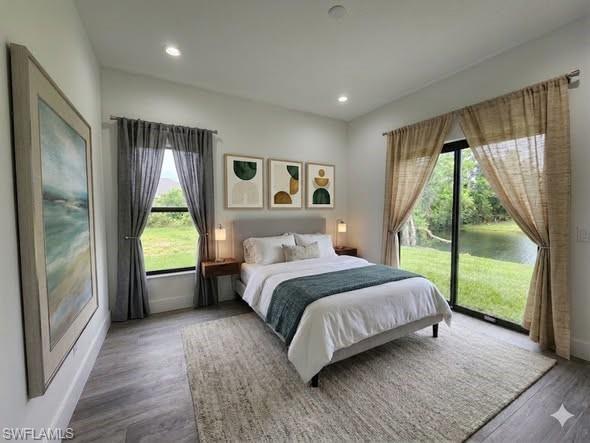 Wood-finish flooring, recessed lighting, and a large sliding glass door opening to a water feature