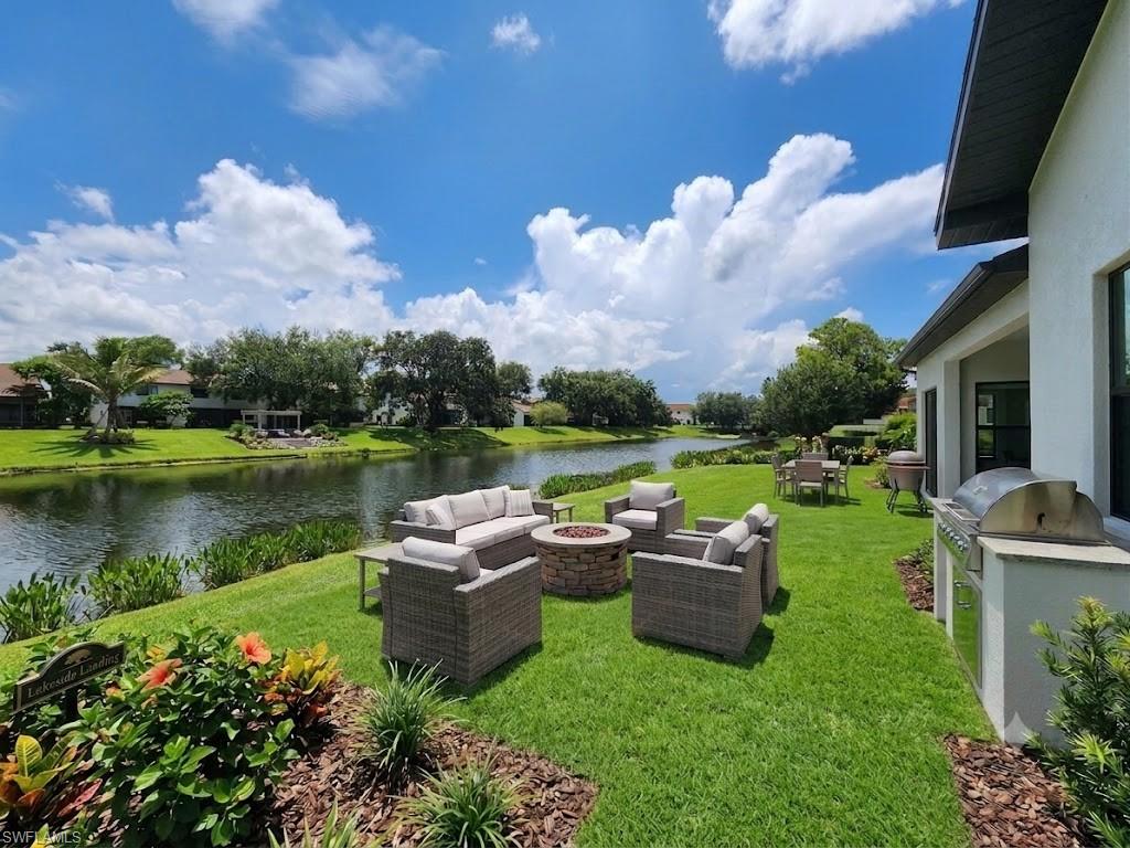 Expansive backyard featuring a manicured lawn, lush landscaping, and a waterfront setting