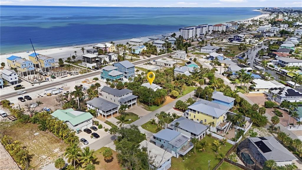 Coastal neighborhood featuring residential properties and mature landscaping, with direct proximity to a sandy beachfront and the Gulf of Mexico - Virtually Edited Image