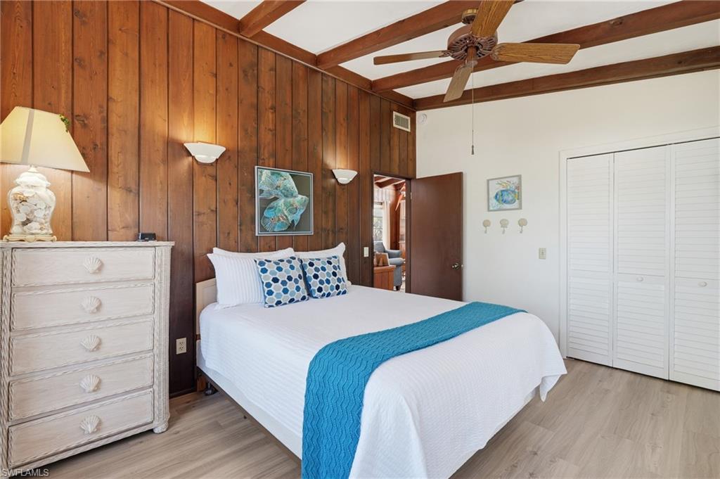 Wood-paneled wall and exposed beam ceiling with a ceiling fan - Virtually Edited Image