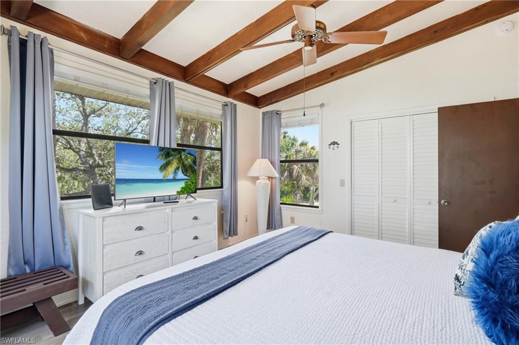 Room featuring wood-beam vaulted ceiling and light wood-finish flooring - Virtually Edited Image