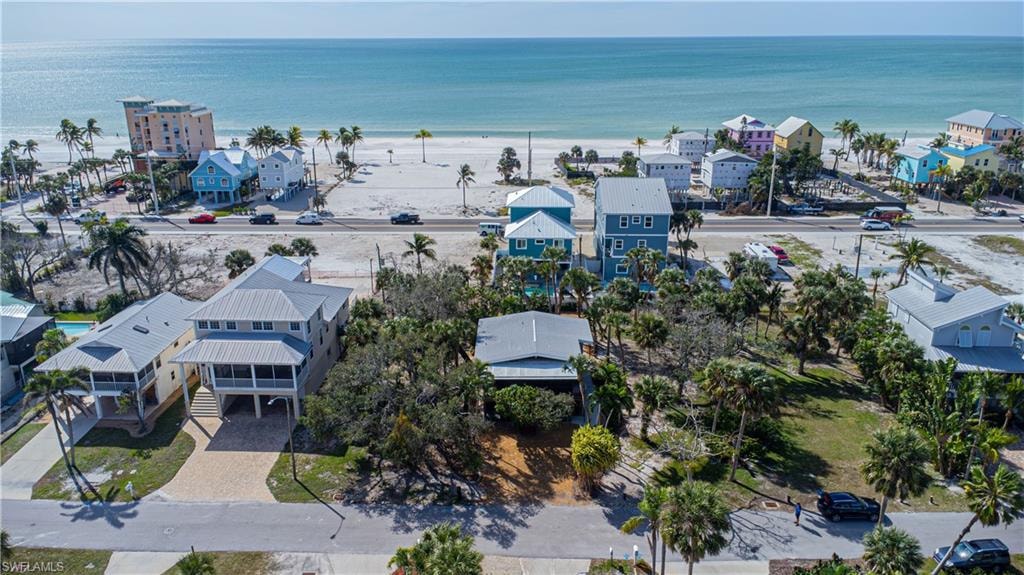 Coastal setting featuring beachfront access, white sand, and mature palm trees - Virtually Edited Image