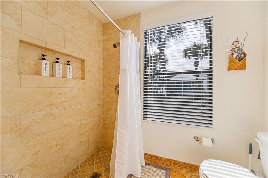 Shower with large format tan wall tile, a recessed niche, and a mosaic tile floor - Virtually Edited Image