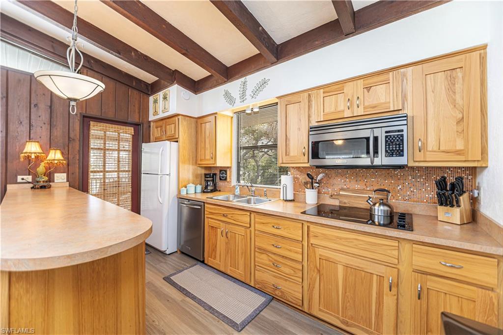 Kitchen with wood cabinetry, light-toned countertops, and a mosaic tile backsplash - Virtually Edited Image