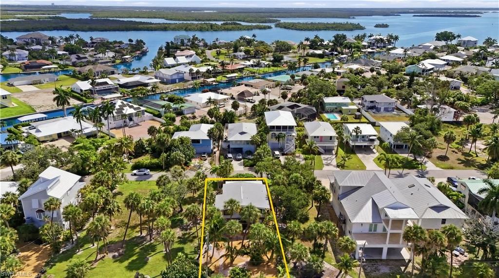 Aerial perspective showcasing a residential property with surrounding mature palm trees - Virtually Edited Image