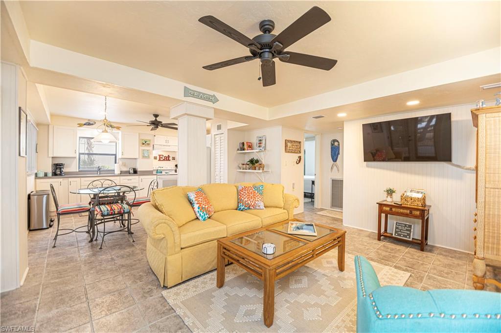 Open-concept living area featuring large format tile flooring, recessed lighting, and a ceiling fan - Virtually Edited Image