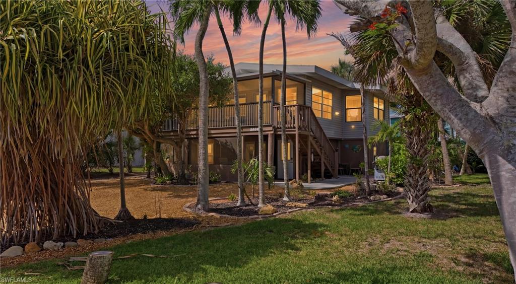 Elevated residence featuring a wooden exterior, multiple windows, and a spacious outdoor deck - Virtually Edited Image