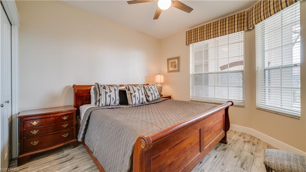 Bedroom with baseboards, ceiling fan, a closet, and light wood-type flooring