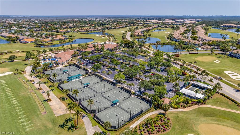 Aerial perspective of suburban area featuring a golf club and a nearby body of water