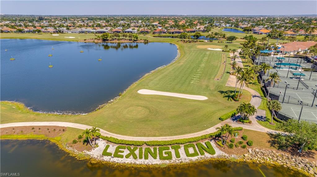 Aerial perspective of suburban area featuring a nearby body of water and a golf course