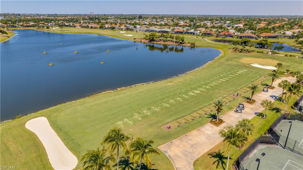 Aerial perspective of suburban area featuring a local golf course and a large body of water