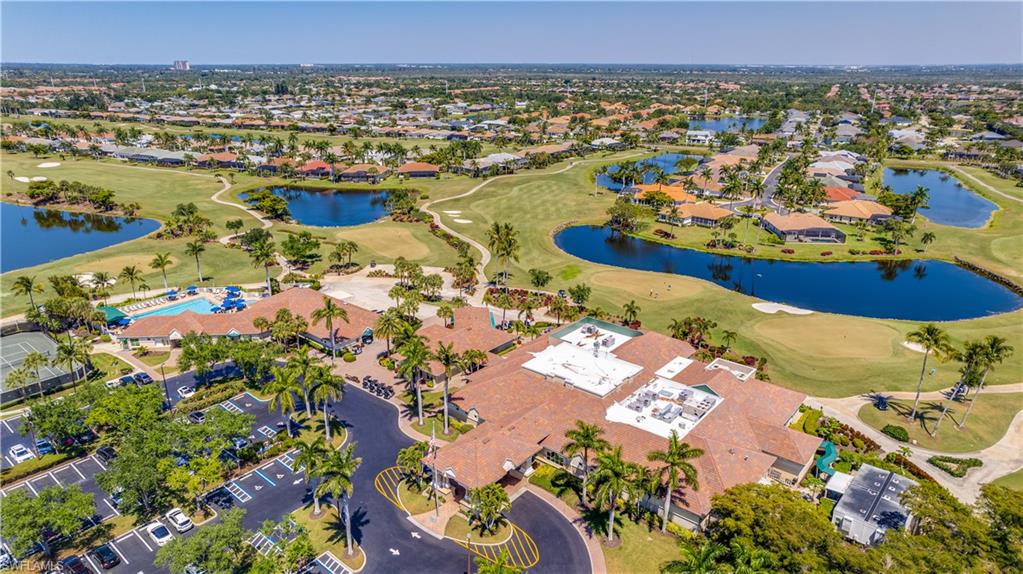 Aerial view of property's location featuring a golf club, a large body of water, and nearby suburban area