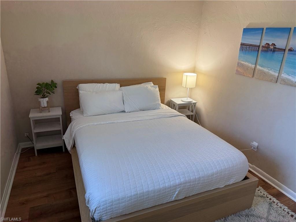 Bedroom with baseboards and dark wood finished floors