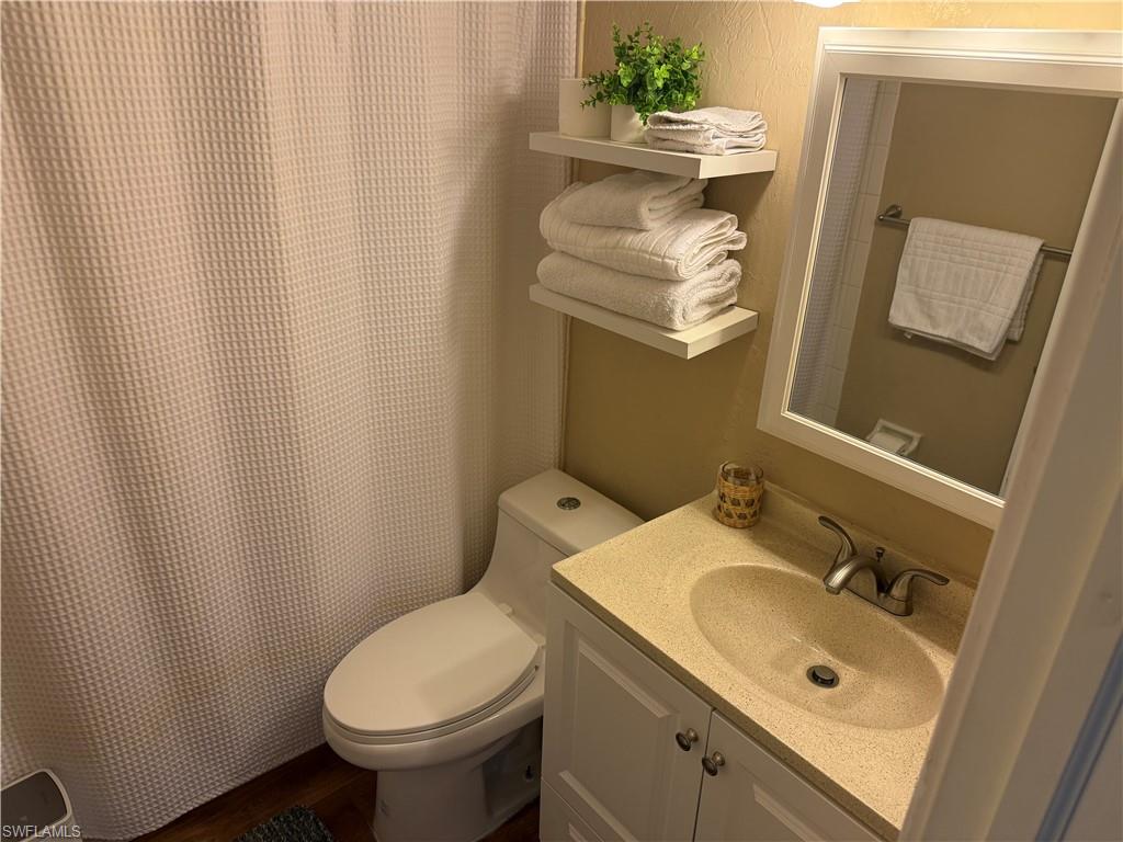 Full bathroom with curtained shower and vanity