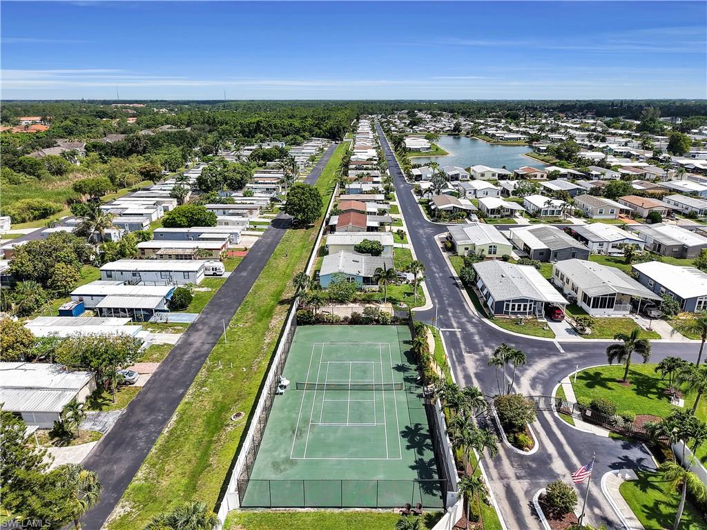 Aerial perspective showcasing a residential community with a tennis court