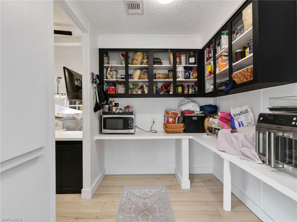 Dedicated pantry space featuring light wood-finish flooring