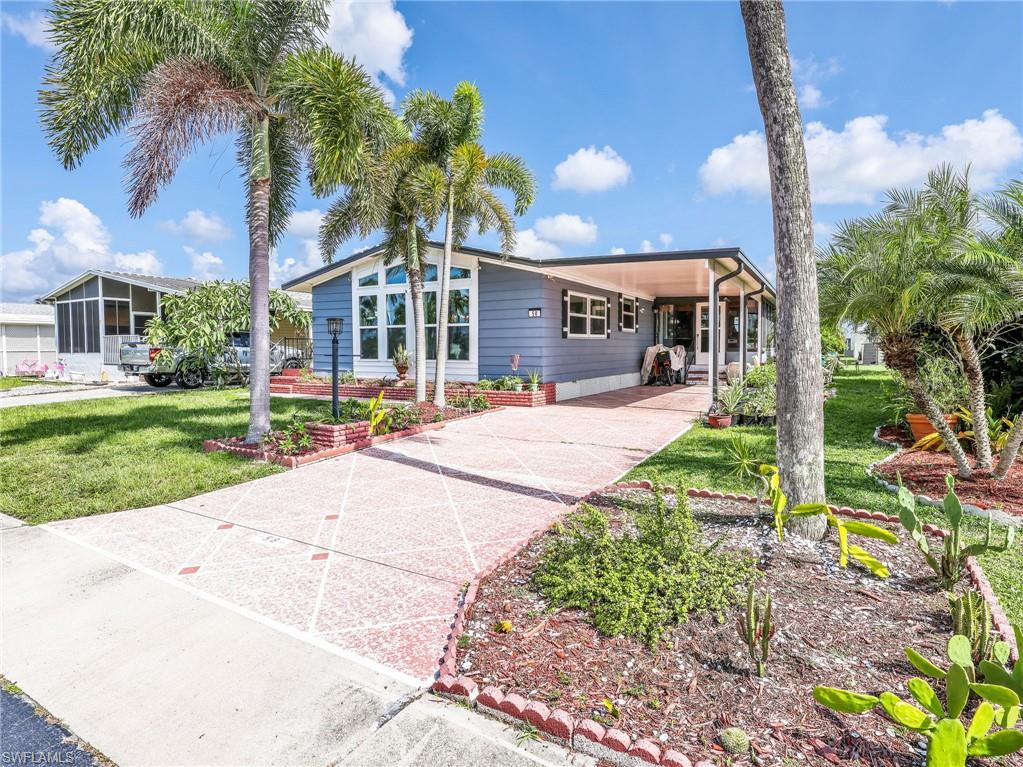 Blue siding residence featuring a covered front entry and a decorative concrete driveway