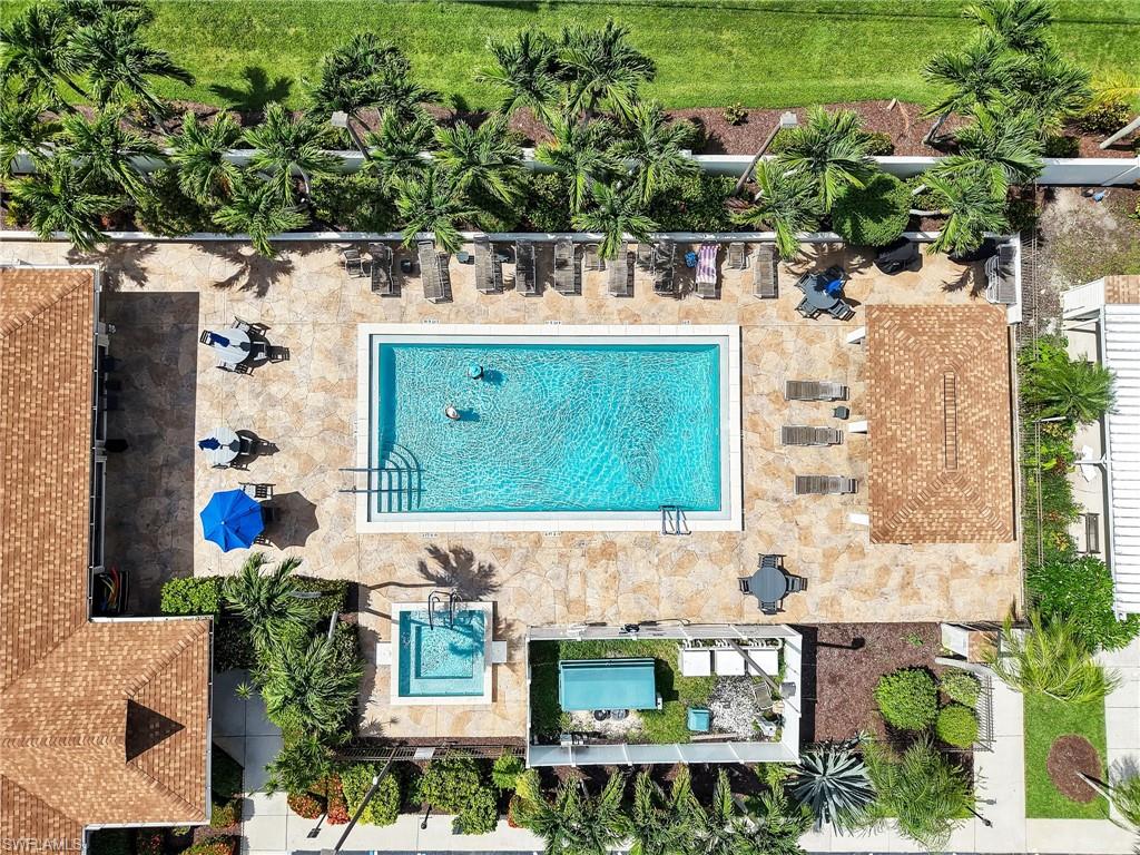 Community pool area featuring a rectangular swimming pool, an adjacent spa, and a surrounding paver deck