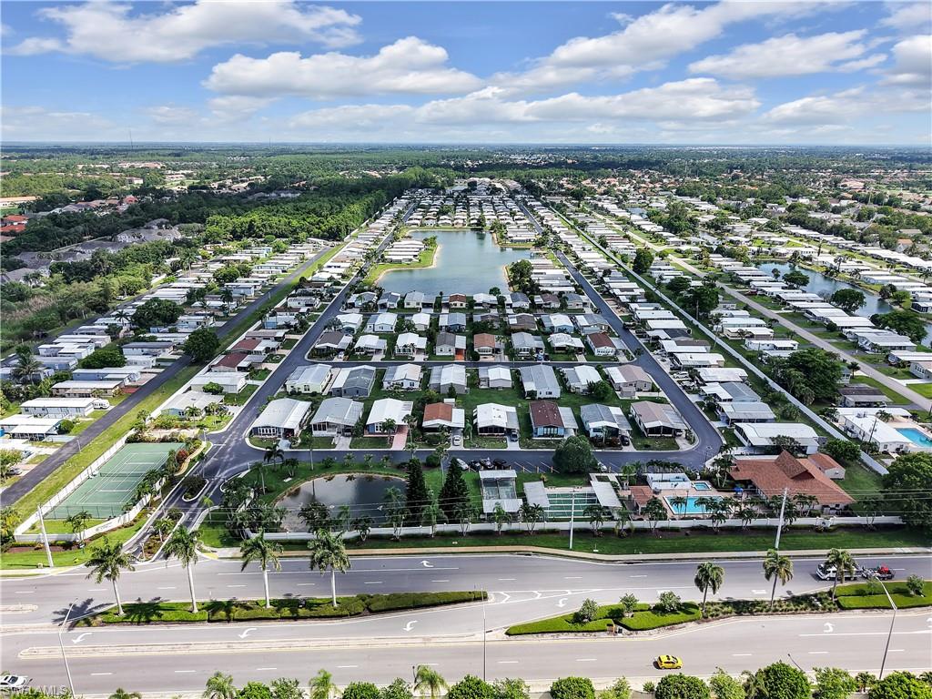 Expansive community featuring multiple residential properties, a central lake, and mature landscaping