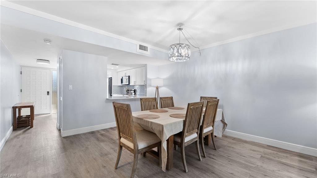 Dining space with light wood-style flooring and a chandelier