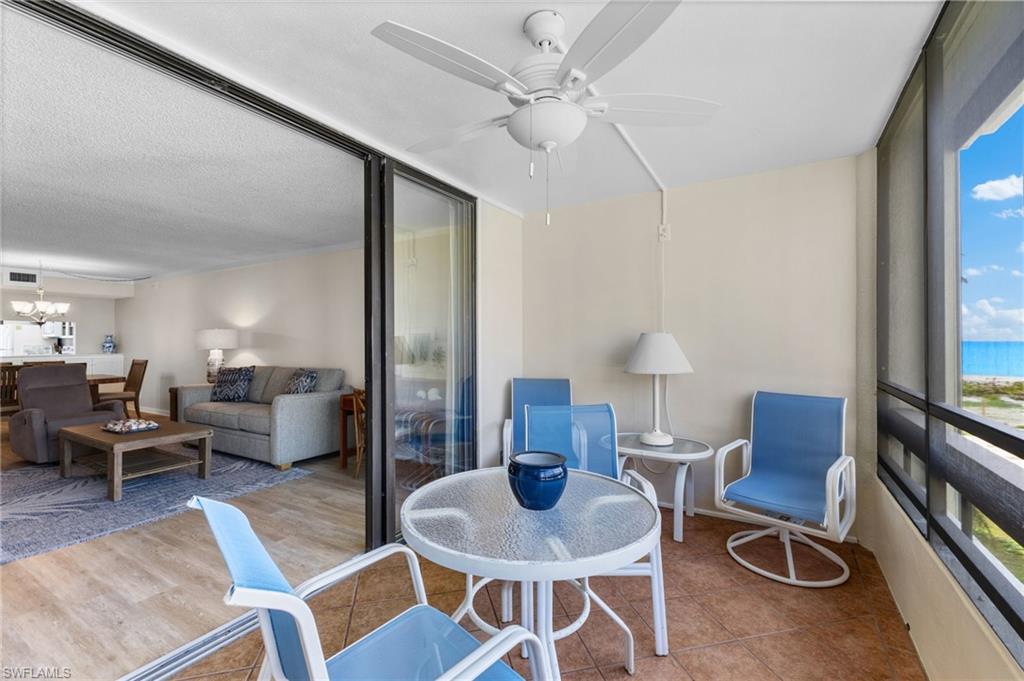 Sunroom / solarium featuring ceiling fan, plenty of natural light, and a chandelier