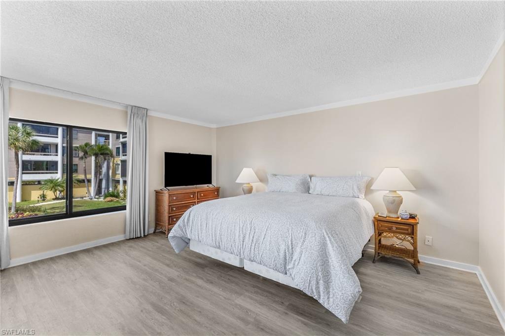 Bedroom with a textured ceiling and wood finished floors