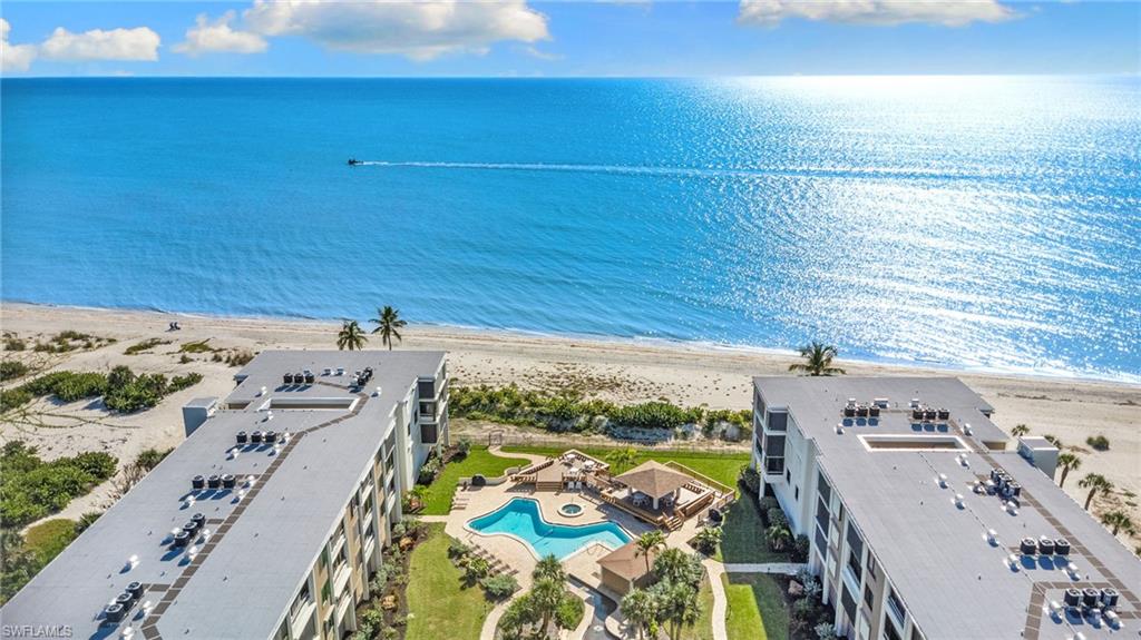 Drone / aerial view of a pool area and expansive beach