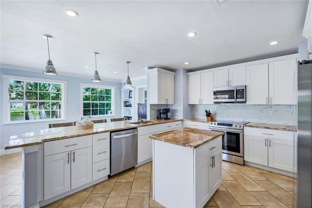 Kitchen Featuring Stainless Steel Appliances, Granite Countertops, and White Cabinetry