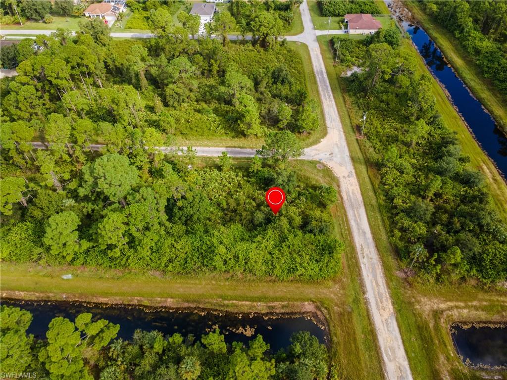 Aerial view of property and surrounding area with a nearby body of water