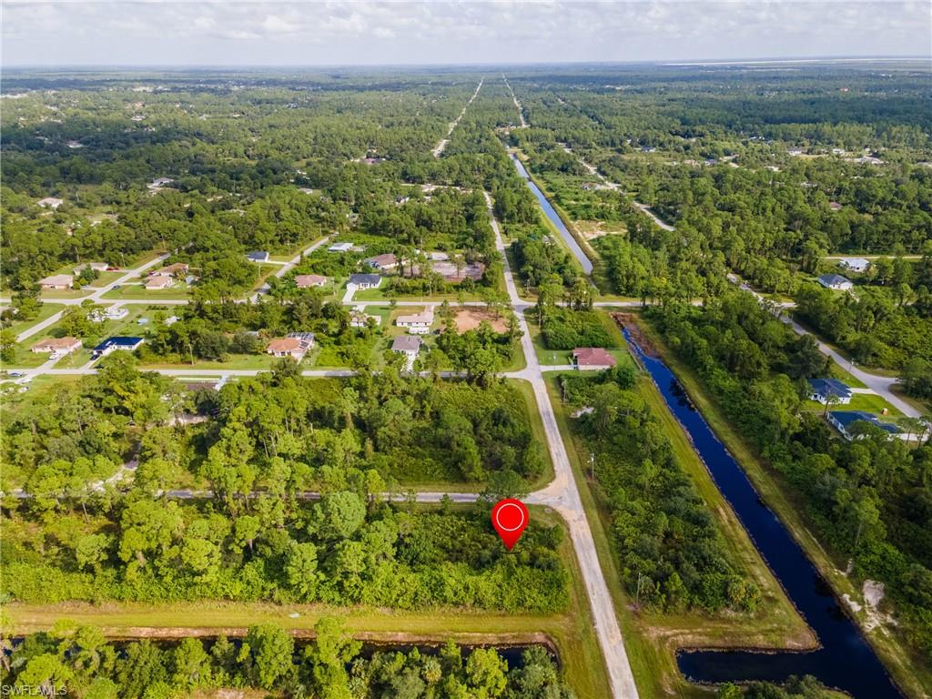 Aerial overview of property's location featuring a large body of water and a forest