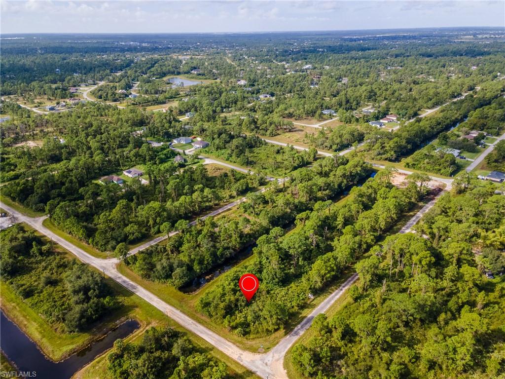 Aerial view of property and surrounding area with a heavily wooded area