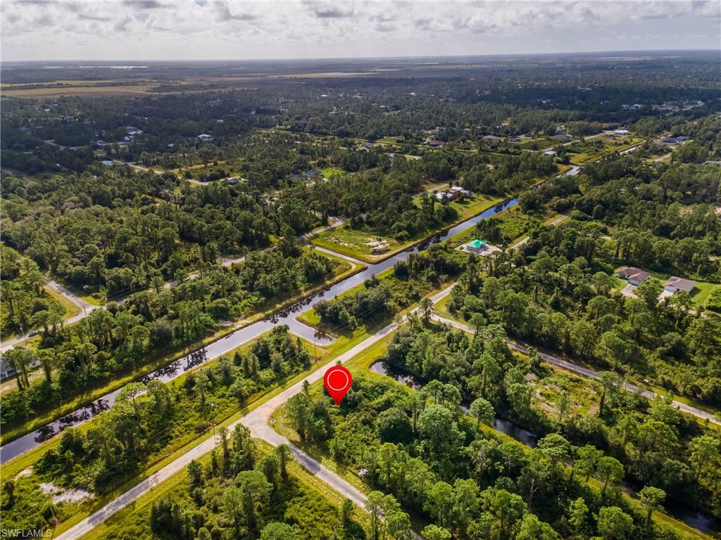 Aerial view of property and surrounding area featuring a forest