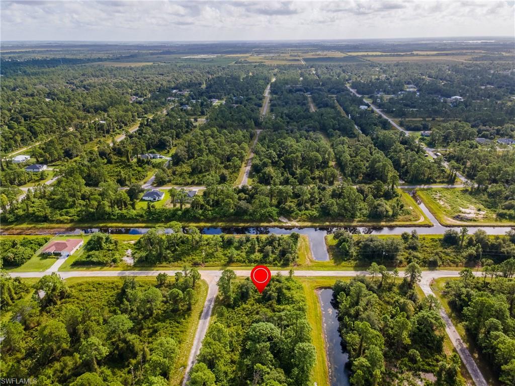 View of property location featuring a nearby body of water and a heavily wooded area