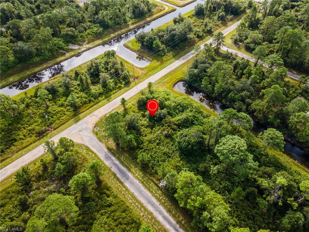 Aerial view of property's location featuring a nearby body of water and a tree filled landscape