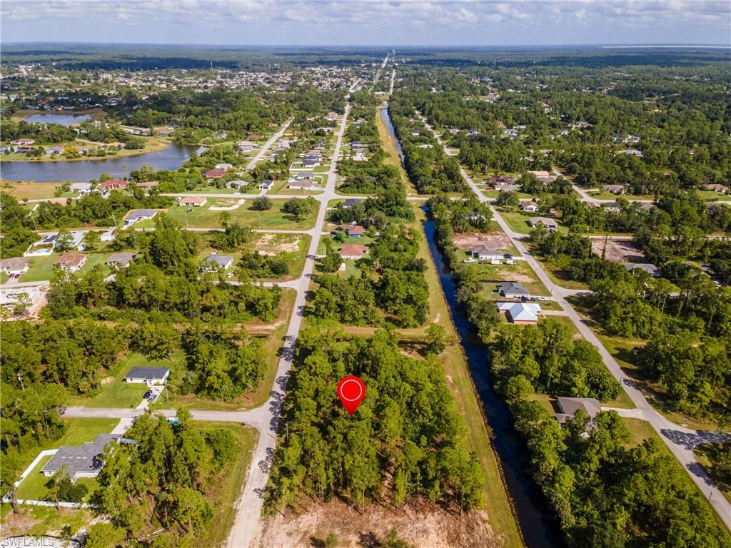 Aerial view of property and surrounding area with a large body of water and nearby suburban area