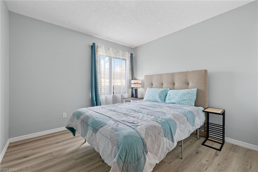 Bedroom with a textured ceiling and light wood-type flooring
