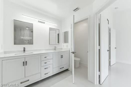 Bathroom featuring double vanity and toilet