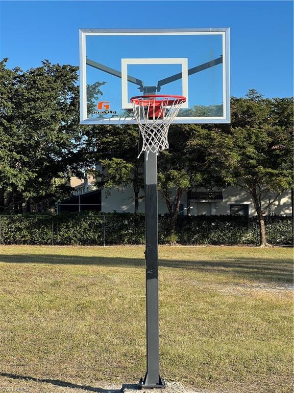 View of basketball court featuring a yard