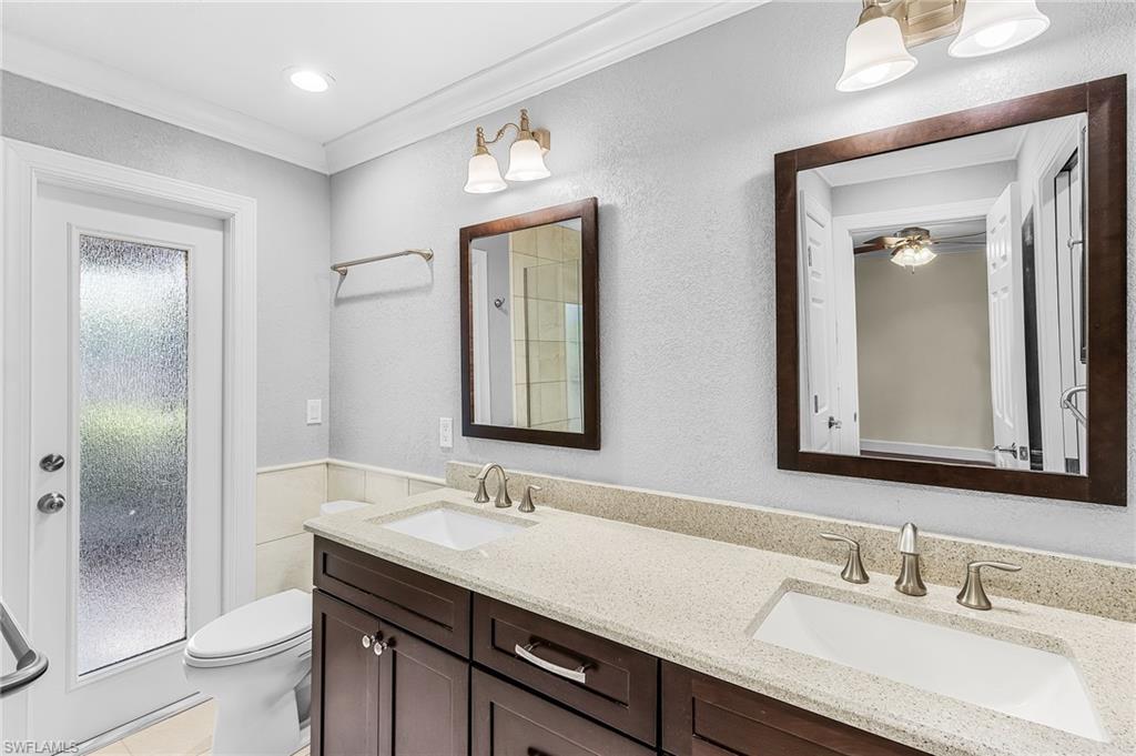 Dual vanity with wood-finish cabinetry and light-toned countertops