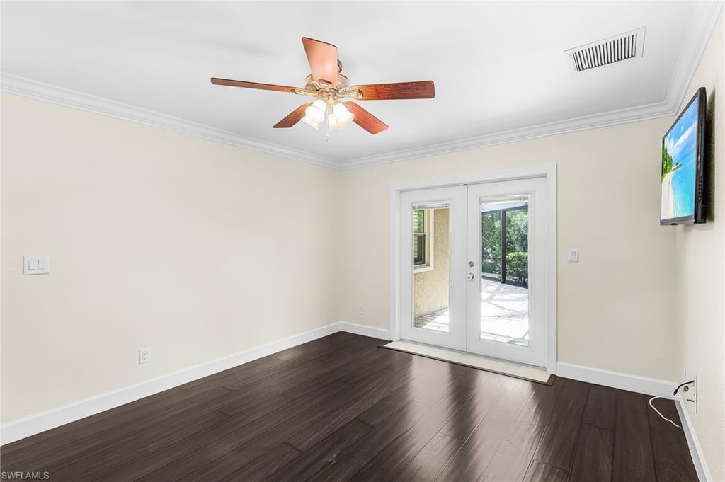 Wood-finish flooring throughout, featuring a ceiling fan with integrated lighting, crown molding, and white baseboards