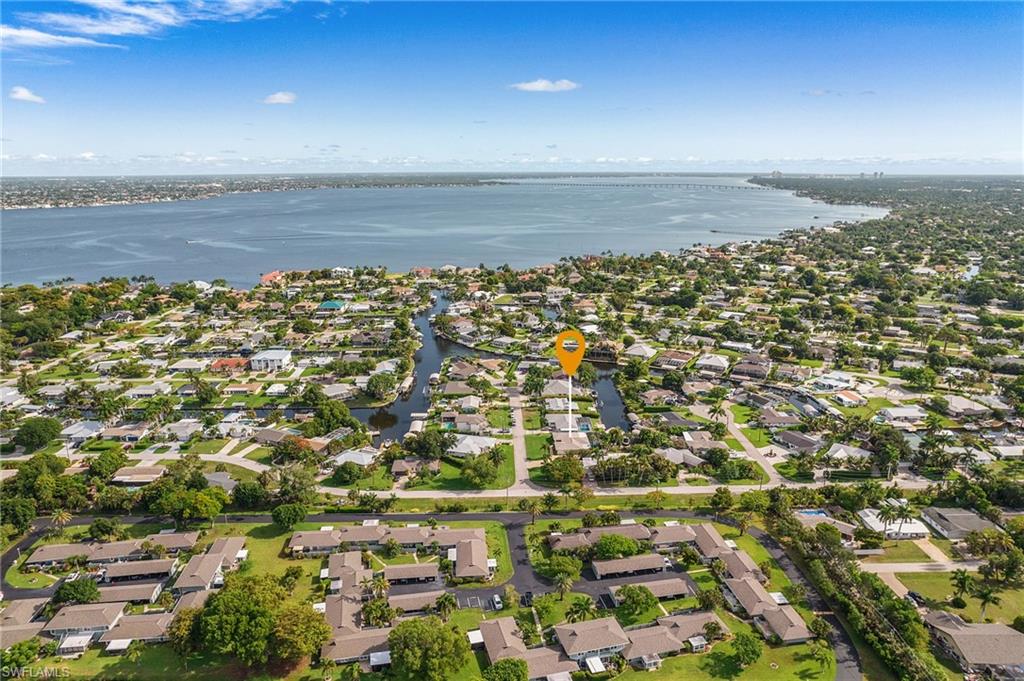 Aerial perspective showcasing a residential area with canal access, featuring numerous properties with private docks