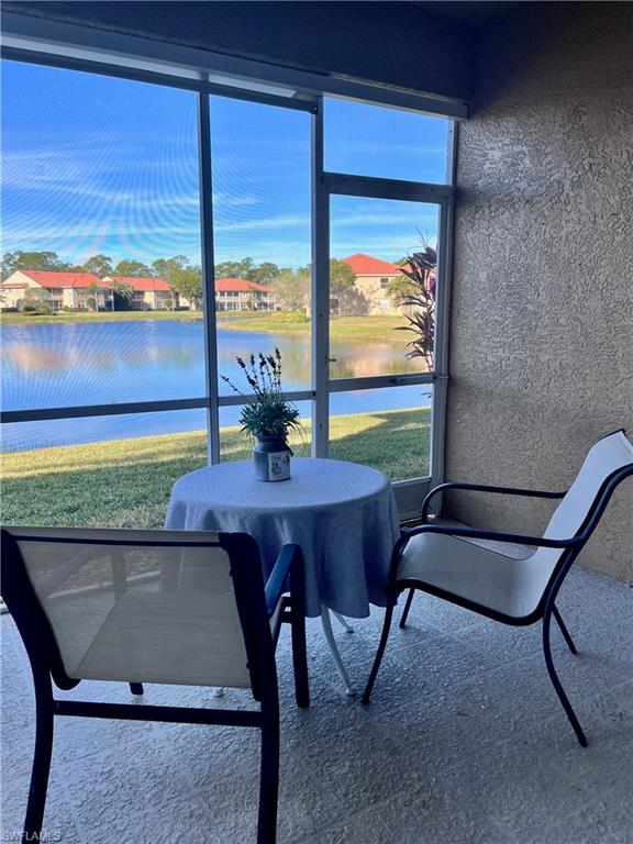 Sunroom / solarium featuring a water view