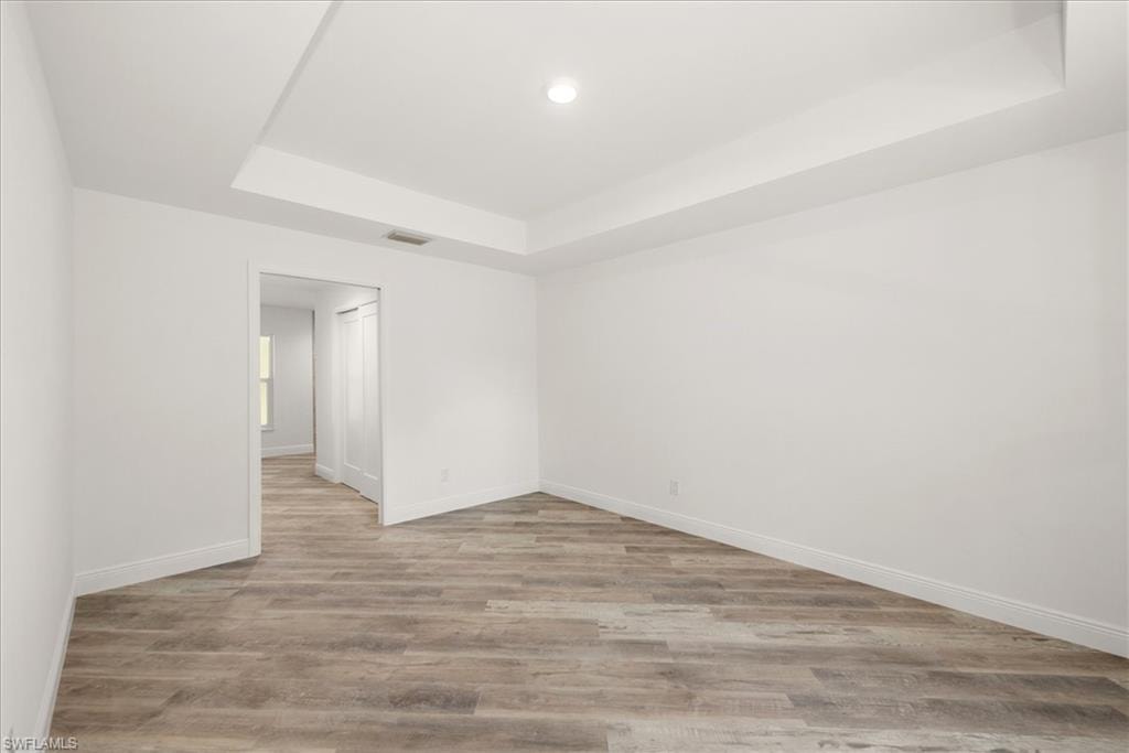 The primary bedroom has a tray ceiling, a pocket door leading toward the bathroom, and dual closets. One standard style and the other is a huge walk in closet!