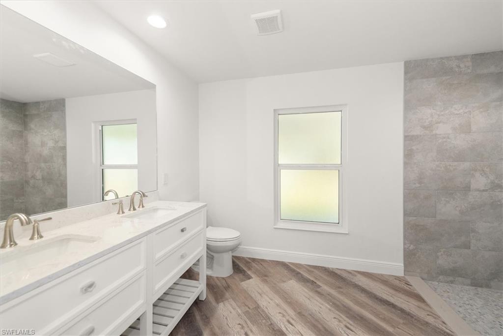 Primary bathroom has dual sinks with quartz countertops, soft close drawers, and a walk in shower with 12 x 24 plank pocelain tile.