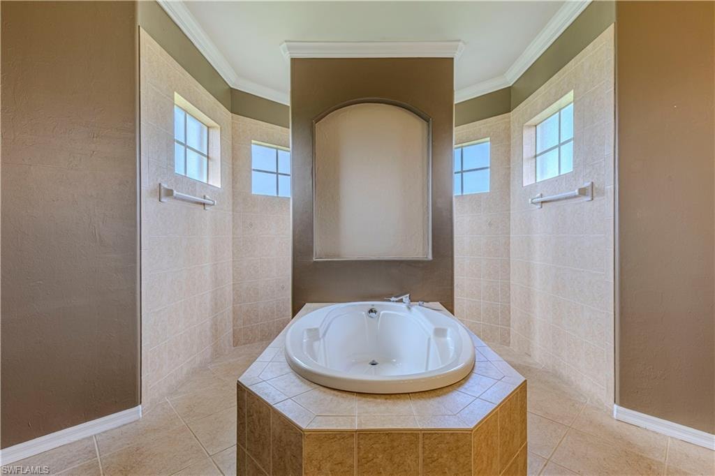 Built-in soaking tub with tile surround, complemented by tiled walls and flooring