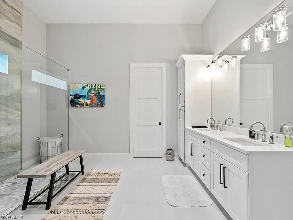 Spacious bathroom featuring a dual vanity with white cabinetry and quartz countertops