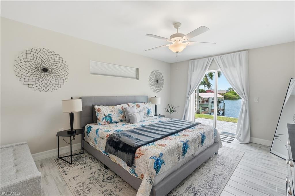 Bedroom featuring white plank-style flooring and a ceiling fan with integrated lighting